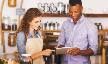 man and woman in store using tablet for business