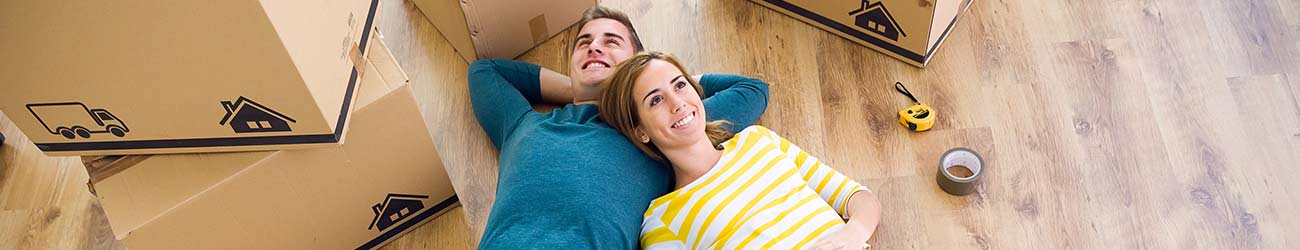 Young couple lying on the floor of a new home